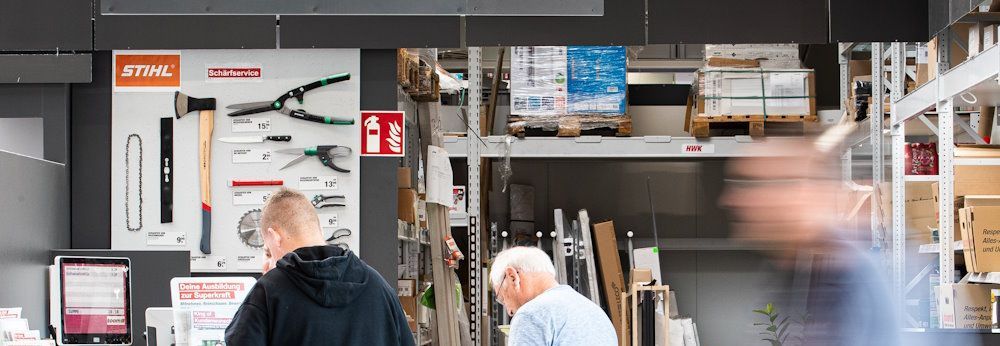 Zwei Personen an einem Abholschalter in einem Baumarkt